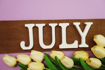 July alphabet letter and tulip flower with space copy on purple background