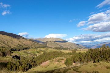 Mountain landscape with fertile valley below steep forests and ancient agricultural terraces at sunset