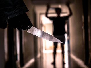 Hand with knife following young terrified in the apartment. man Bandit is holding a knife in hand, Threat Concept, Murder concept