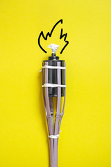 A close up of bamboo fire torch on yellow background.