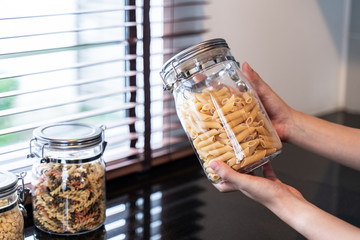 hand hold bottle of pasta in kitchen