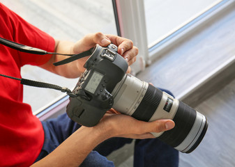 Male photographer with camera indoors