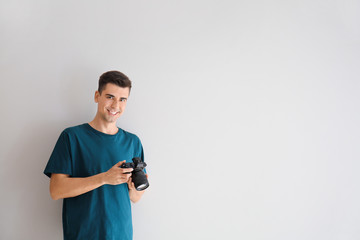 Male photographer on light background