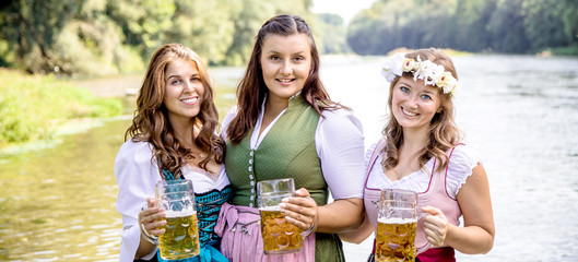 Five friends having fun on Bavarian RIver and clinking glasses with beer