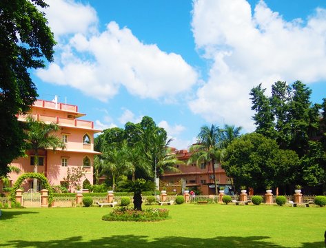 A beautiful garden of green trees and plants  with colourful flower and other nice structures at Mayapur in India.