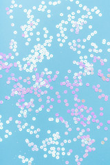 Holographic sparkles on blue pastel background. Festive backdrop