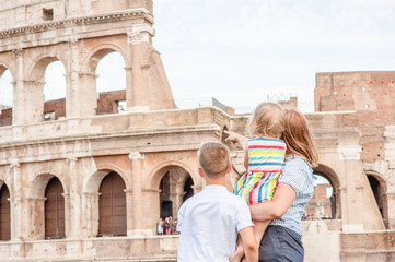 Family traveling. Mother with children visiting a coliseum in rome. Back view. Empty space for text