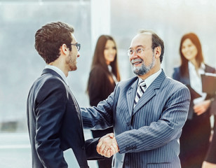 meeting of two business partners are shaking hands at a presenta