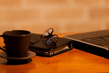 テーブルに置かれたコーヒーとノートパソコン