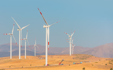 Wind turbines generating electricity with bright blue sky