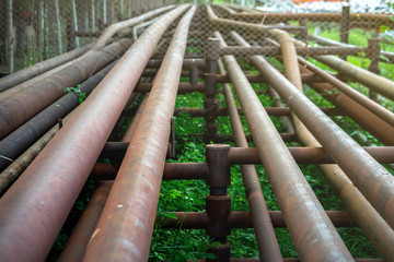 Crude oil and gas pipeline which is used to transfer petroleum from well site to process station. A part of pipeline in photo is located at public road side . Selected focus at some point on the pipe.