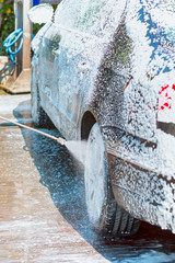 Car wash foam texture. Washing black car with active foam