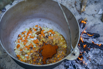 cooking pilaf in a cauldron on the fire