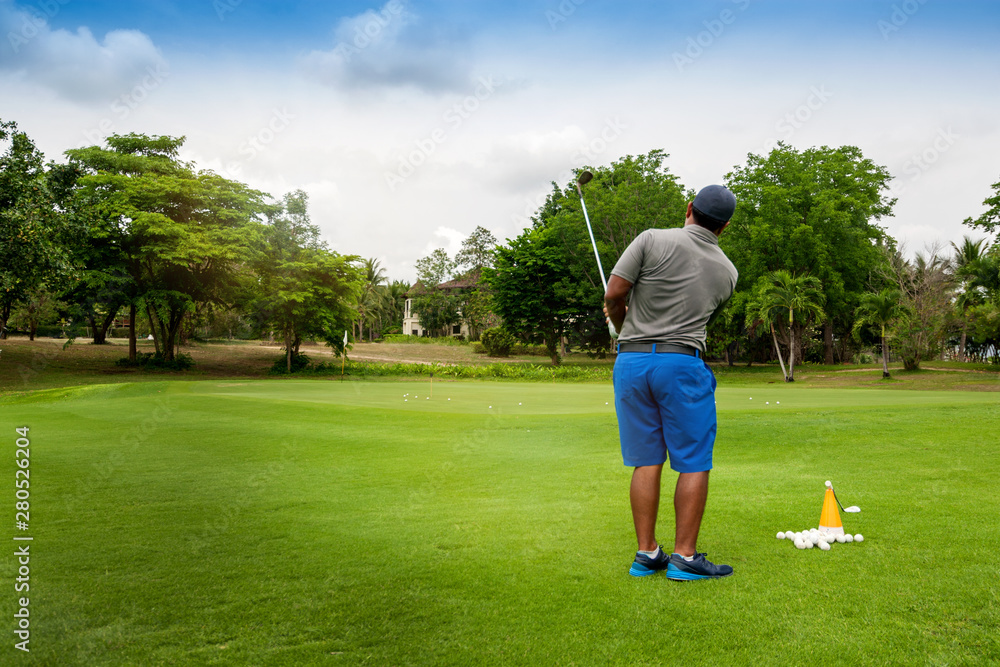 Wall mural Professional golfer training drill skill sweeping golf ball to hole on golf course on holiday , vacation on background.