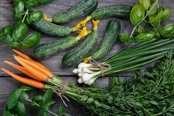 Fresh vegetables and fresh greens on a wooden table. Top view.