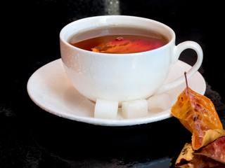 Autumn leaves with a white cup of tea