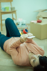 寝ながらスマホを操作する女性