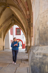 Obraz na płótnie Canvas Lady walks in the streets of Europe using location app in her smartphone to search for attractive places