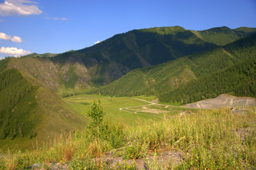 Pasture and fertile valley sandwiched in the mountains. Altai, Siberia, Russia. Landscape.