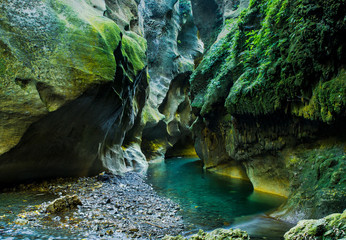 Vivid green river flowing through an underground gorge