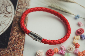  red bracelet on hand. leather bracelet on a colored background, red thread