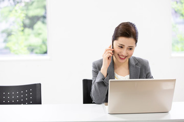 通話しながらPCを操作する女性