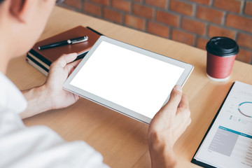 Tablet horizontal screen mockup, Image of Young man working in front of the digital tablet switching on to start his work, looking at screen with a clean screen and blank space for text