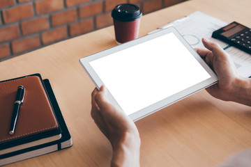 Tablet horizontal screen mockup, Image of Young man working in front of the digital tablet switching on to start his work, looking at screen with a clean screen and blank space for text