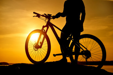 Fototapeta na wymiar mountain biker silhouette in sunrise. Active Lifestyle Concept.