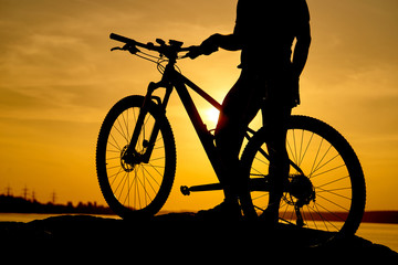 Fototapeta na wymiar Silhouette of a man on mountain-bike, sunset