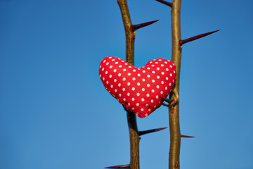 An image of a soft toy in the shape of a heart. Handicraft work.