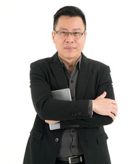 Handsome smiling business man in dark brown shirt holding mobile device, isolated on white background