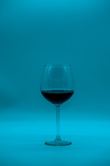 Wine glass with cocktail on blue background