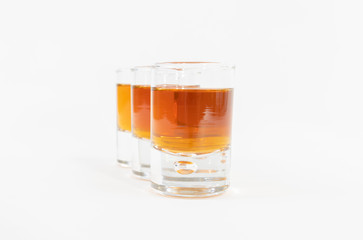 Luxurious and tasty whiskey in three glasses lined up and isolated on a white background
