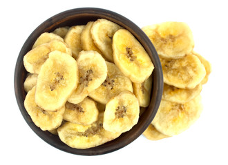 Banana chips in bowl on white background