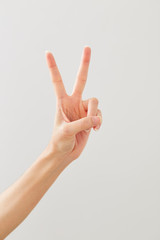 Woman hand showing peace two on white