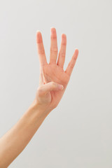 Obraz na płótnie Canvas Young lady's hand gesture: four on white