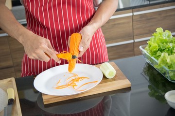 The professional chef with rough hands to grate carrots to prepare cookinging for breakfast