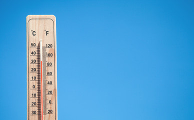 Thermometer on blue sky background.