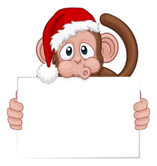 A Christmas monkey animal cartoon character in a Santa hat holding a sign