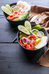 Spring salad with radishes, cucumbers, onions, sweet peppers and sesame oil. Healthy food. Vertical shot