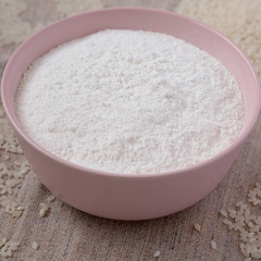 Gluten free rice flour in a pink bowl, side view. Closeup.
