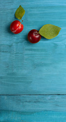 Plums and plums leaves on wooden table. Top view.