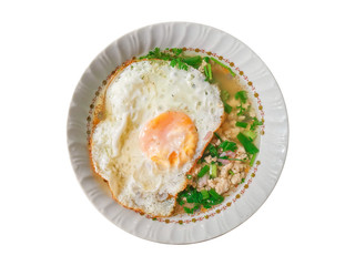 Top view Hot Thai boiled rice soup with minced chicken, fried egg and green scallion chop in bowl isolated on white background.