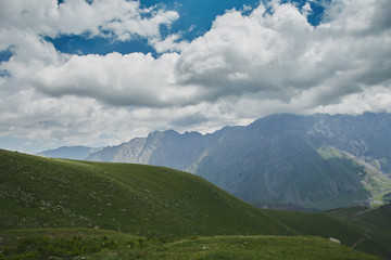 Large scenery of big empty green hill and cloudy sky. Kazbegi Georgia
