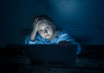 Sad young girl with laptop suffering bullying and harassment online. Cyber bullying victim