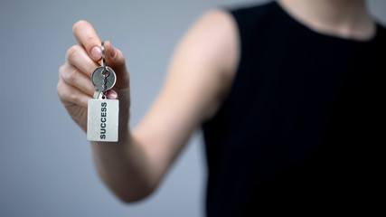 Success inscription on keychain in woman hand, tips to attract money, prosperity