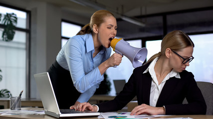 Female boss screaming with megaphone at colleague, authoritarian leadership - obrazy, fototapety, plakaty
