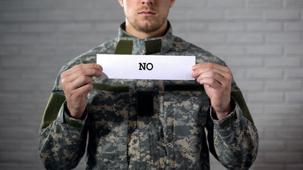 No word written on sign in hands of male soldier, protest against war conflict