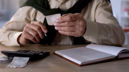 Pensioner looking at checks, calculating expenses for utilities and purchases